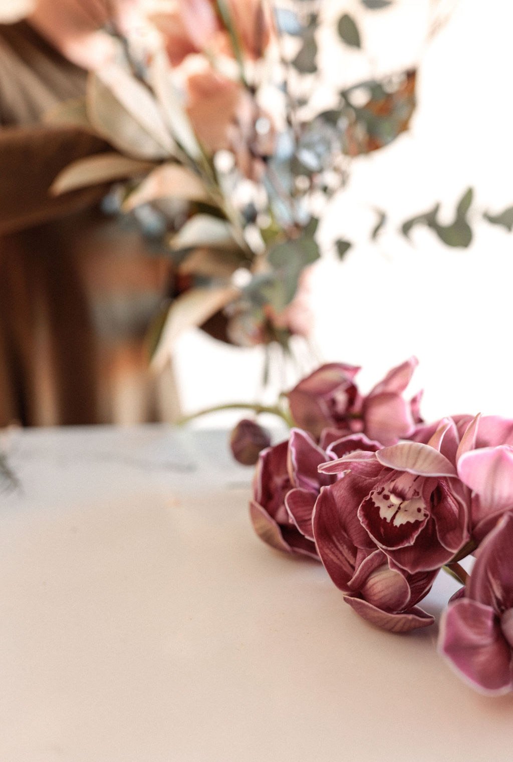 Close-up of vibrant pink orchids with blurred greenery in the background – luxury floral arrangement