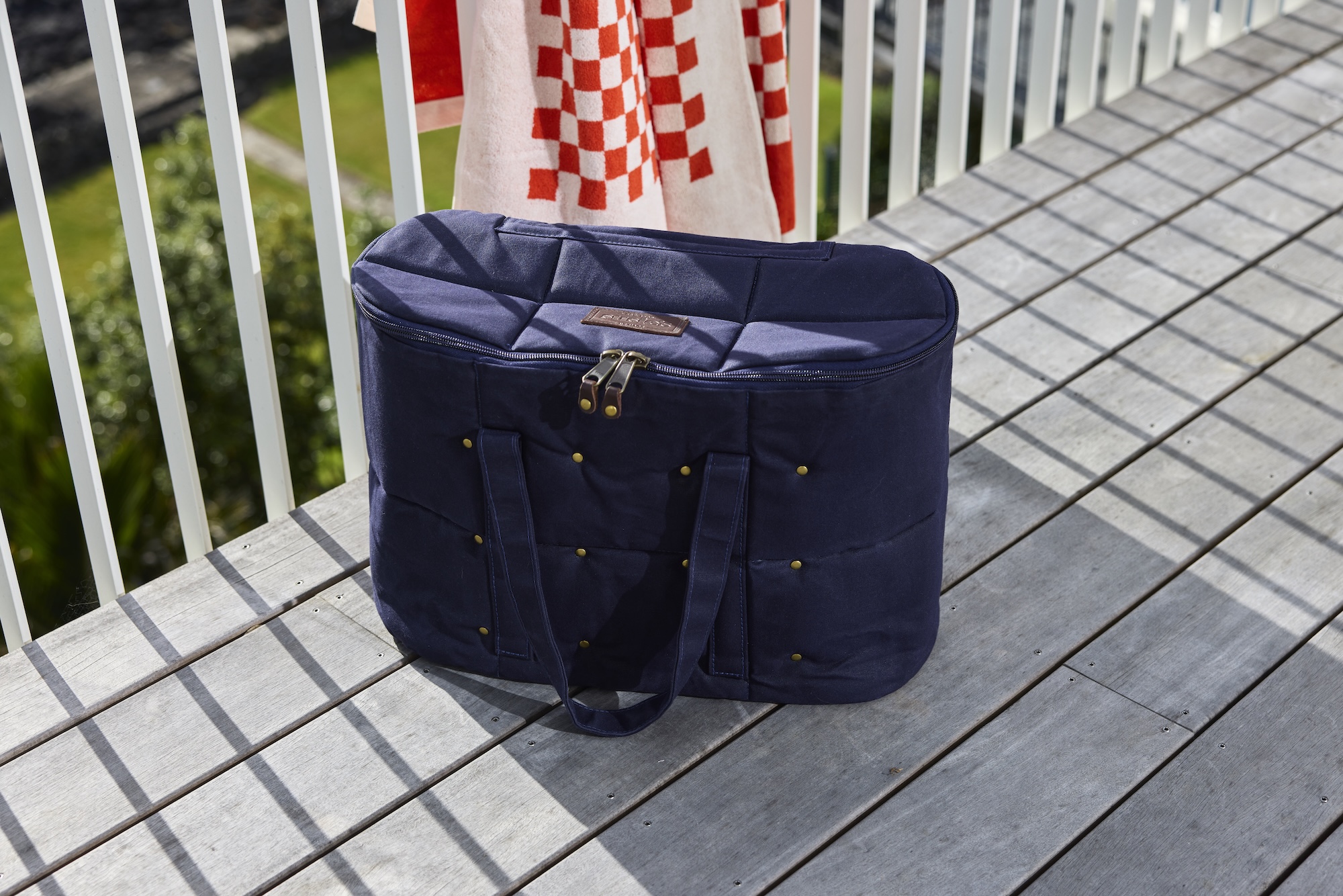 Susie’s Bags navy quilted bottle bag on a sunny balcony rail