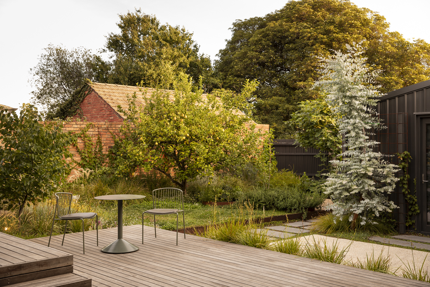 Timber deck with modern outdoor table and lush plantings