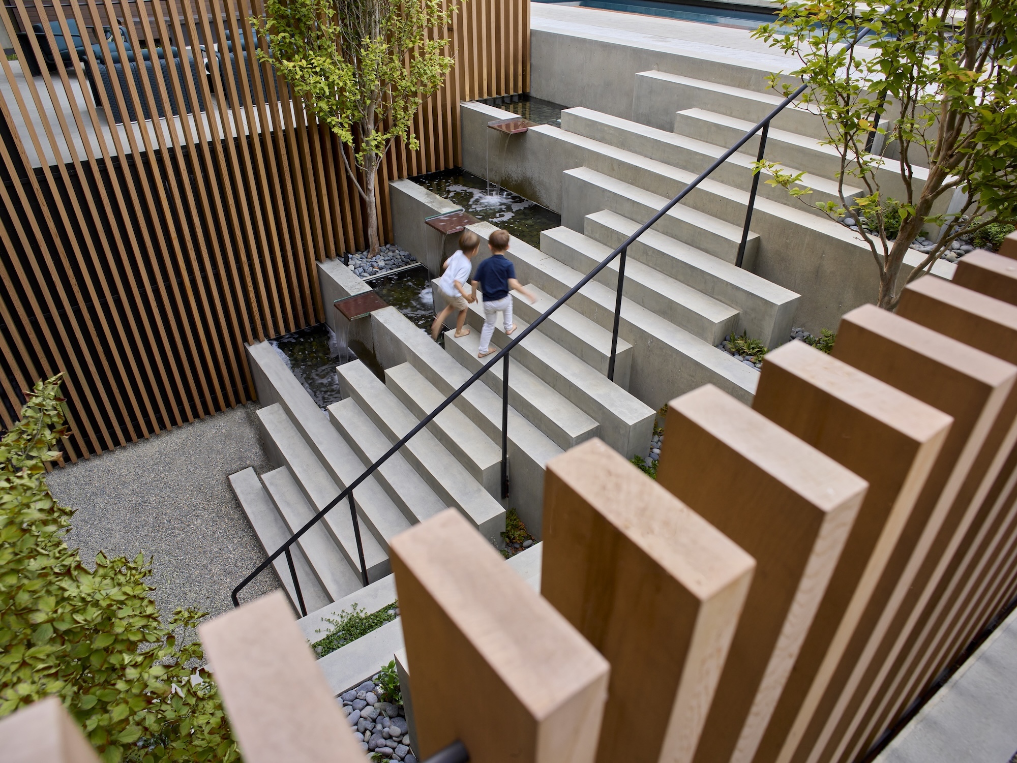Tiered concrete seating with timber detailing in urban garden Outdoor amphitheatre-style seating in landscaped courtyard