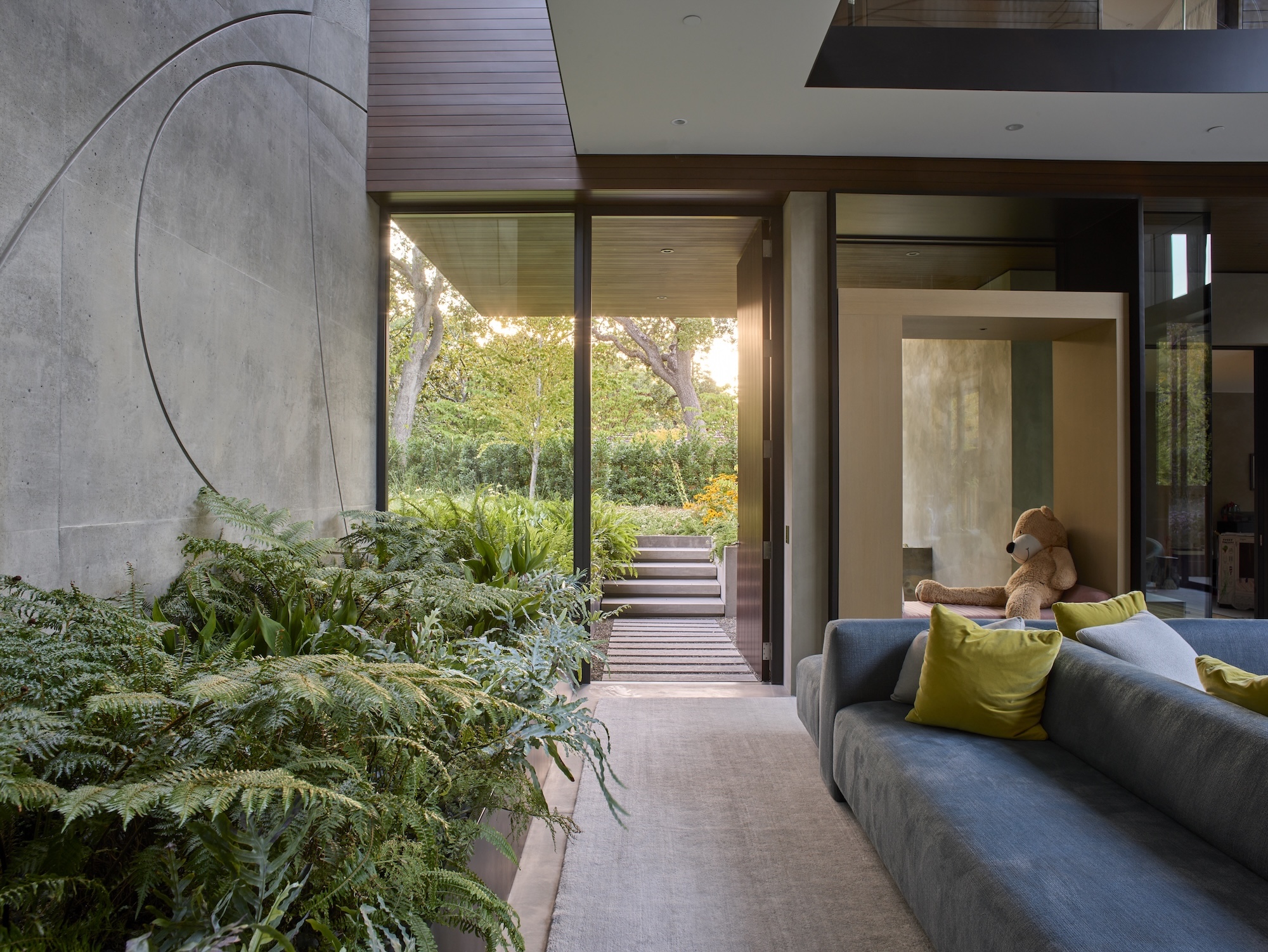Contemporary living space with garden views and indoor greenery Modern home interior opening onto lush garden courtyard