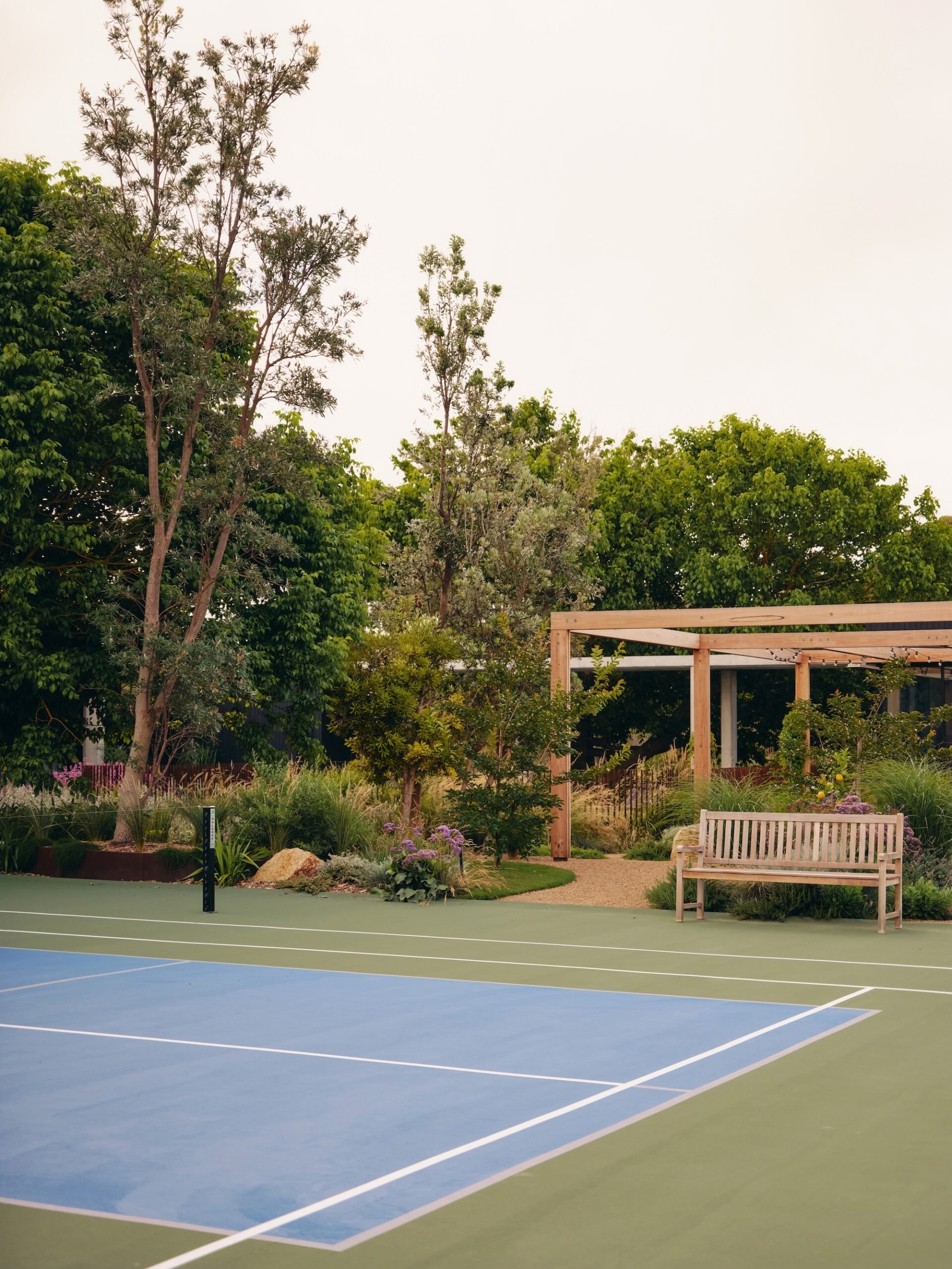 Residential garden with tennis court framed by native and perennial planting