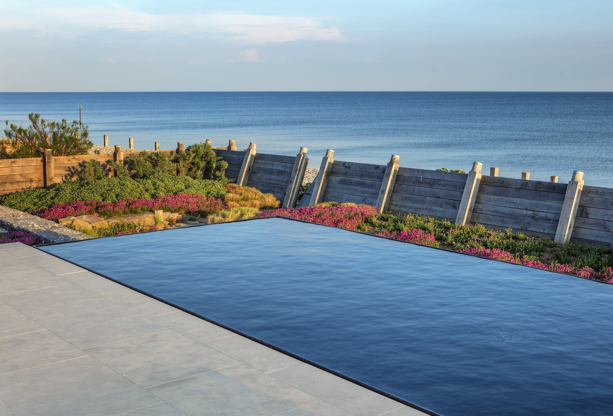 Poolside view with ocean horizon and vibrant flowers