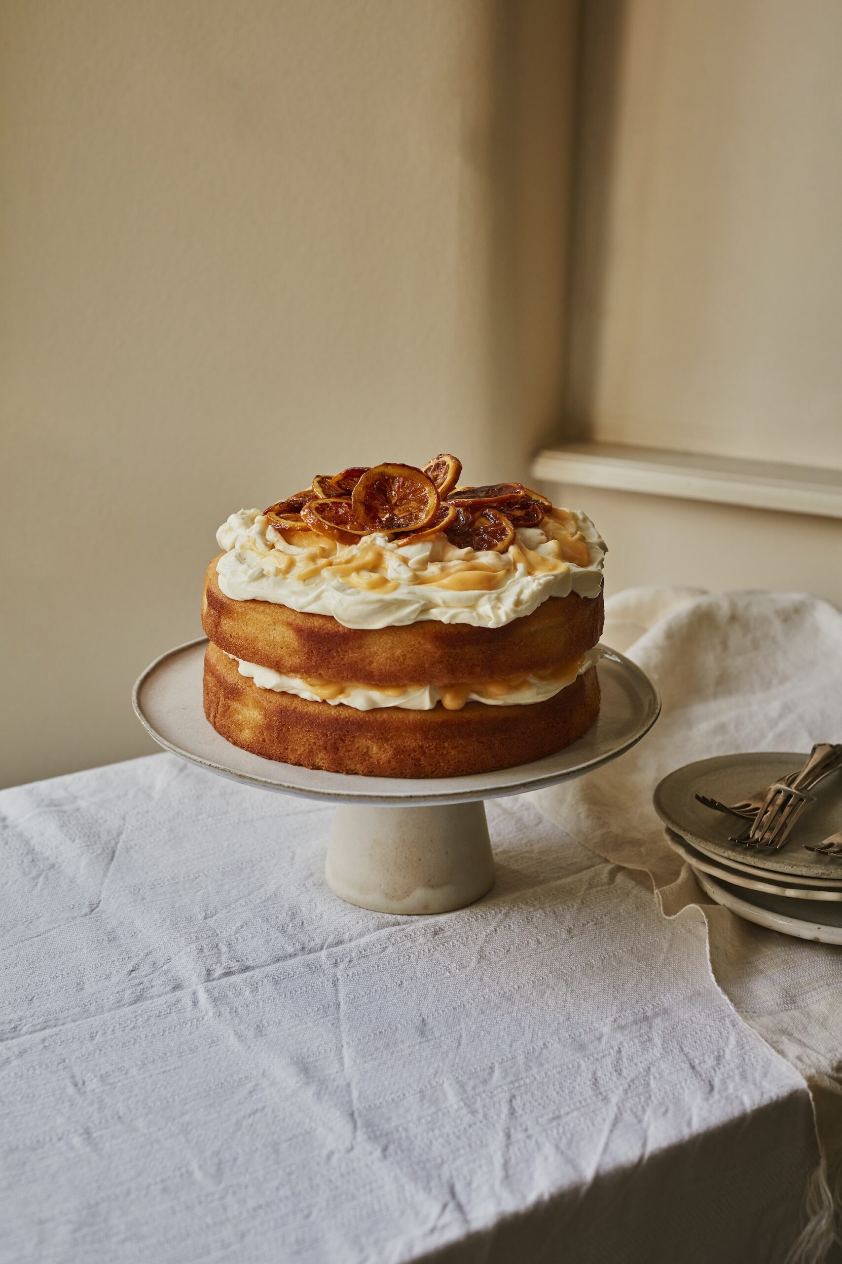 Layered lemon sponge cake topped with cream and pistachio nuts