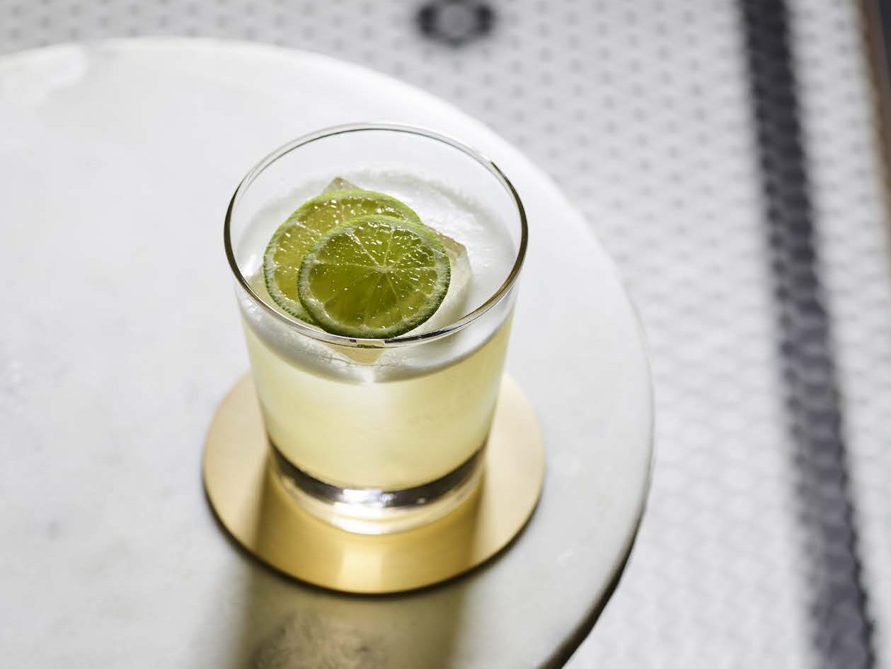 Long Island Gimlet cocktail served with ice in clear short glass with lime garnish