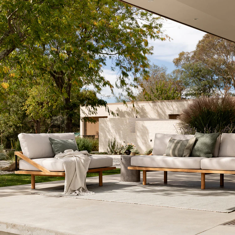 Outdoor patio area with Baya cushioned outdoor furniture surrounded by garden landscaping