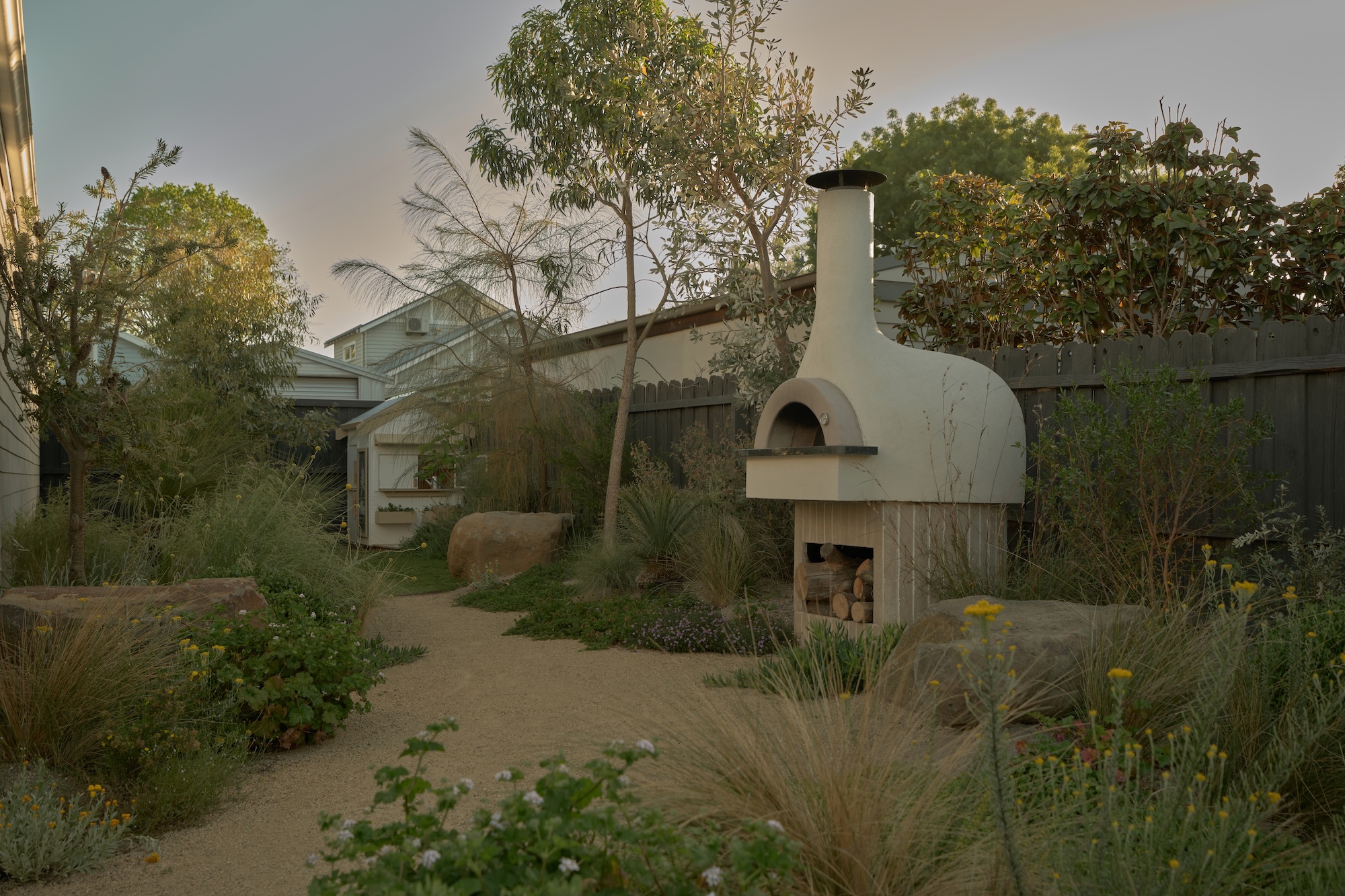 Outdoor dining area with warm tones and natural materials in a Phillip Withers designed Geelong garden