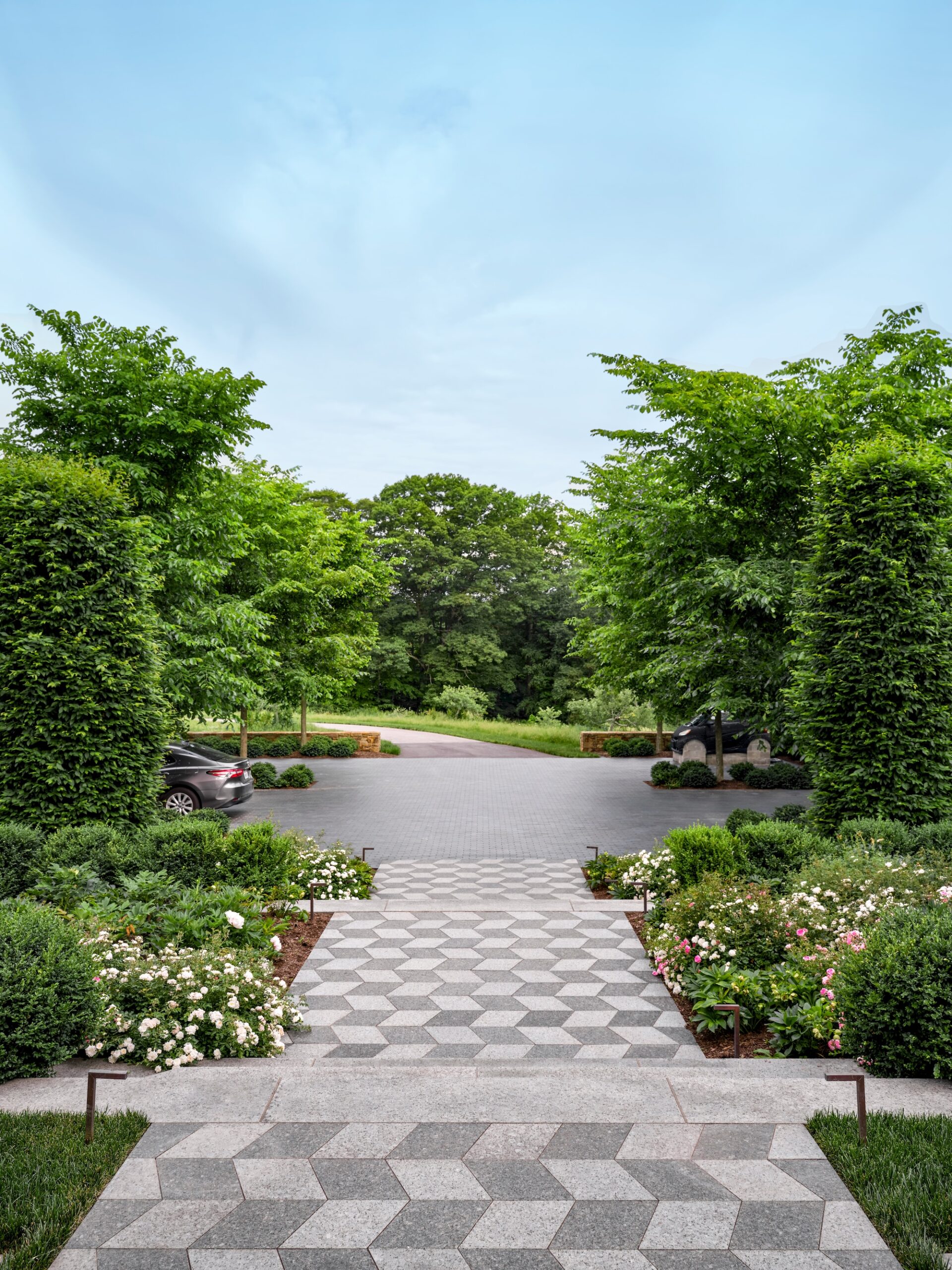 Symmetrical hedged path leading through structured planting designed by Reed Hilderbrand