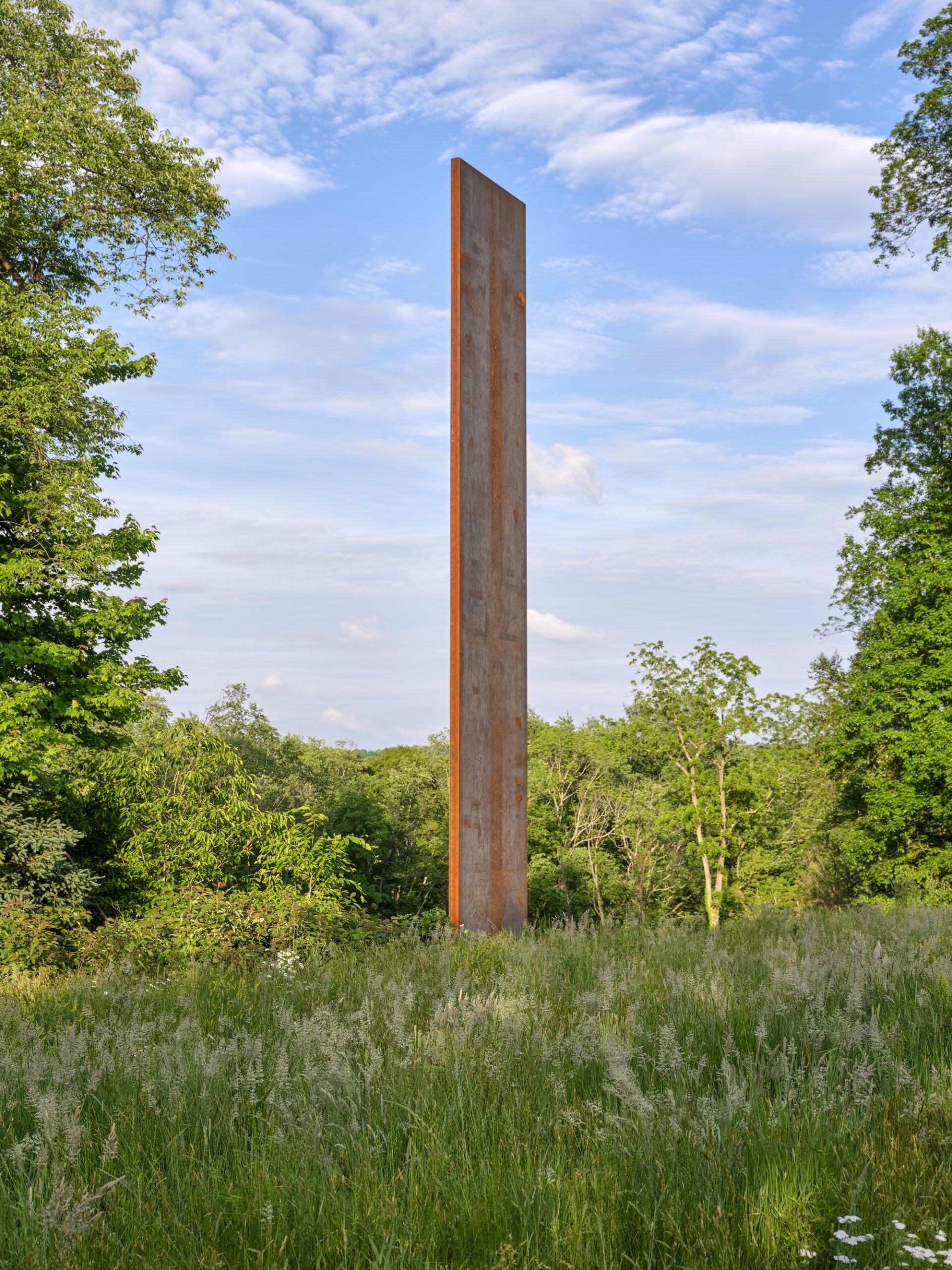 Tall weathered sculpture form rising from meadow at Rowdy Meadows by Reed Hilderbrand