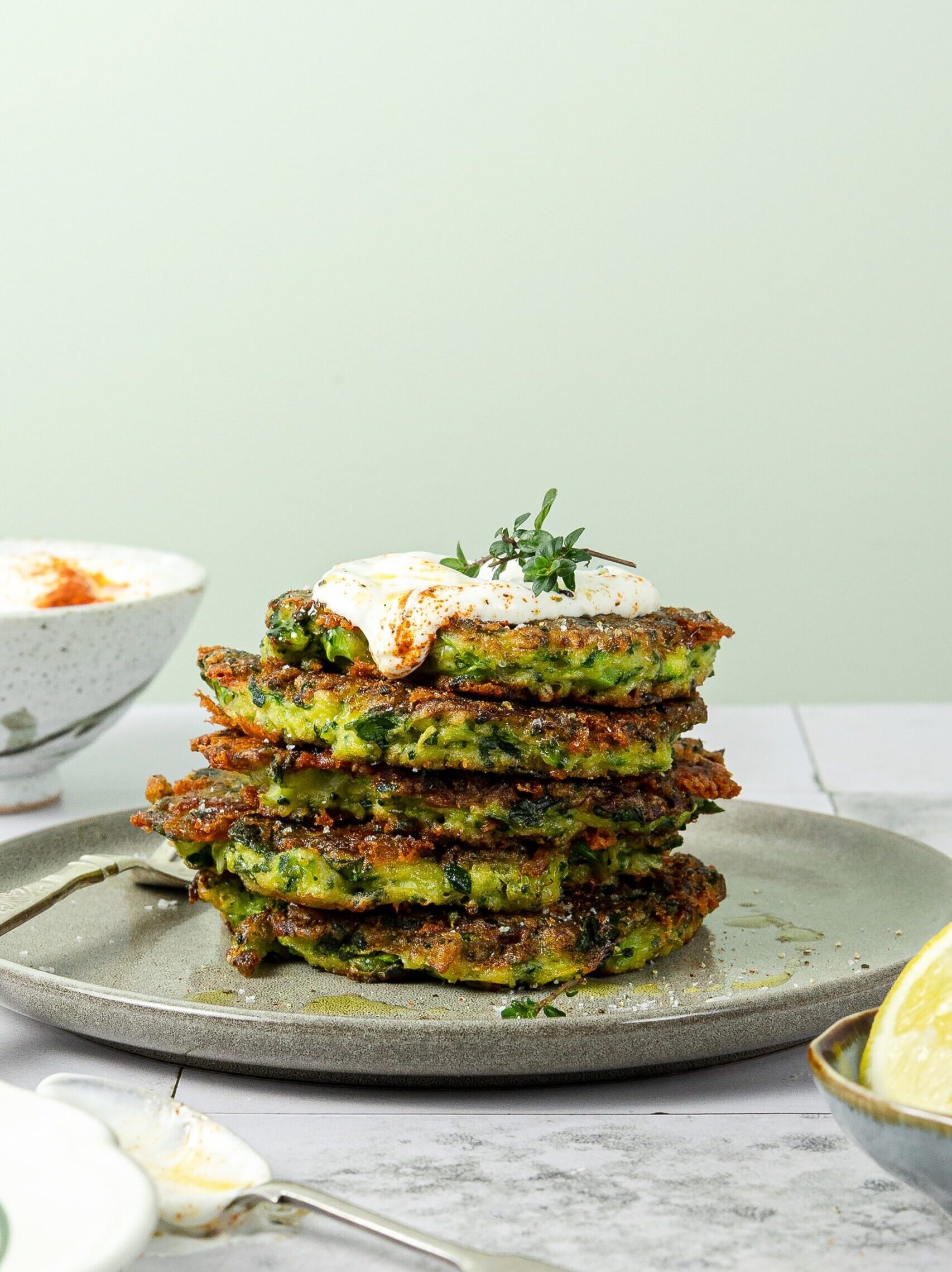 Stack of vegetable fritters on plate served with garlic yoghurt dressing, recipe by Rhiannon Baldock