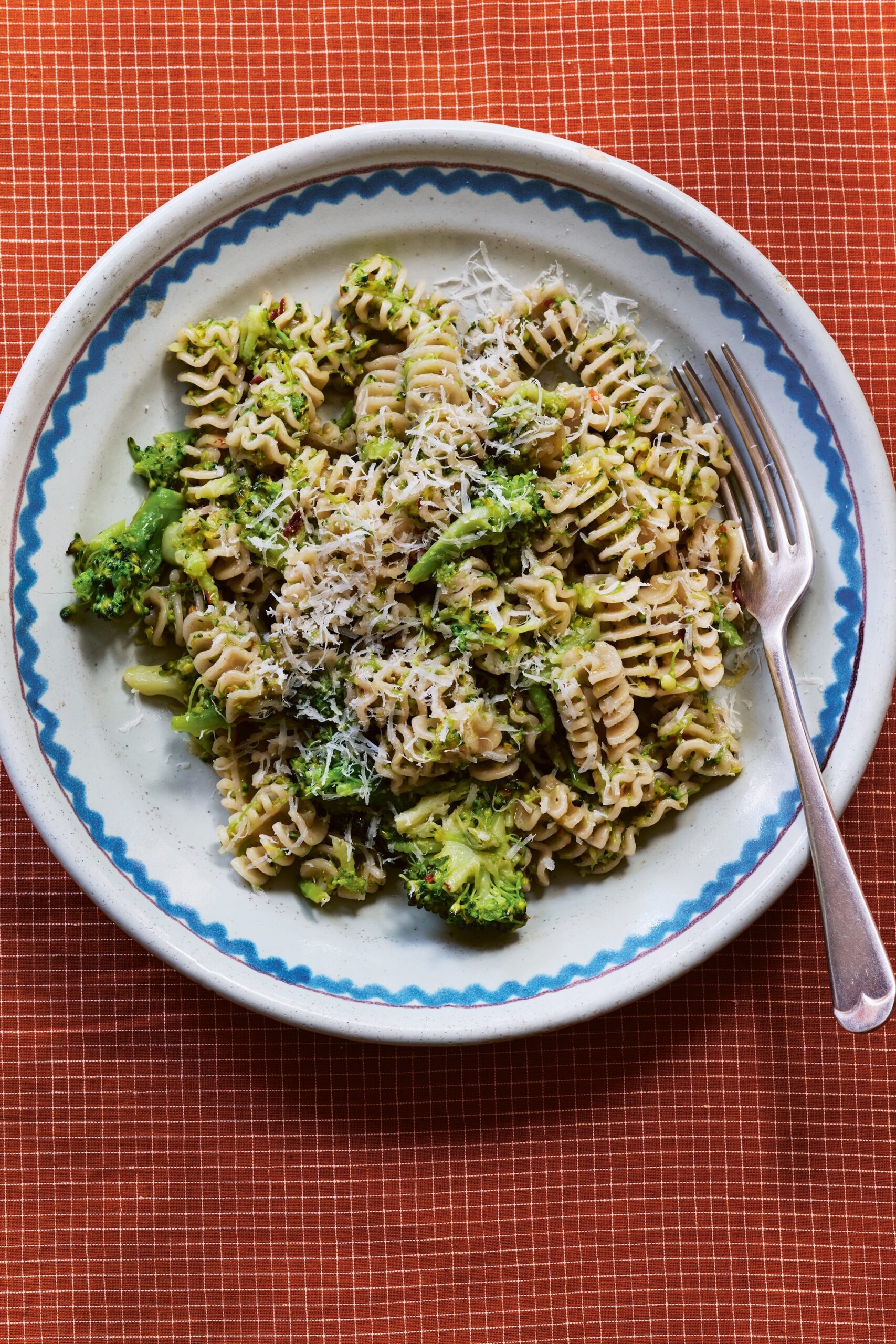 Broccoli, garlic bowl of pasta served on beautiful blue and white china plates