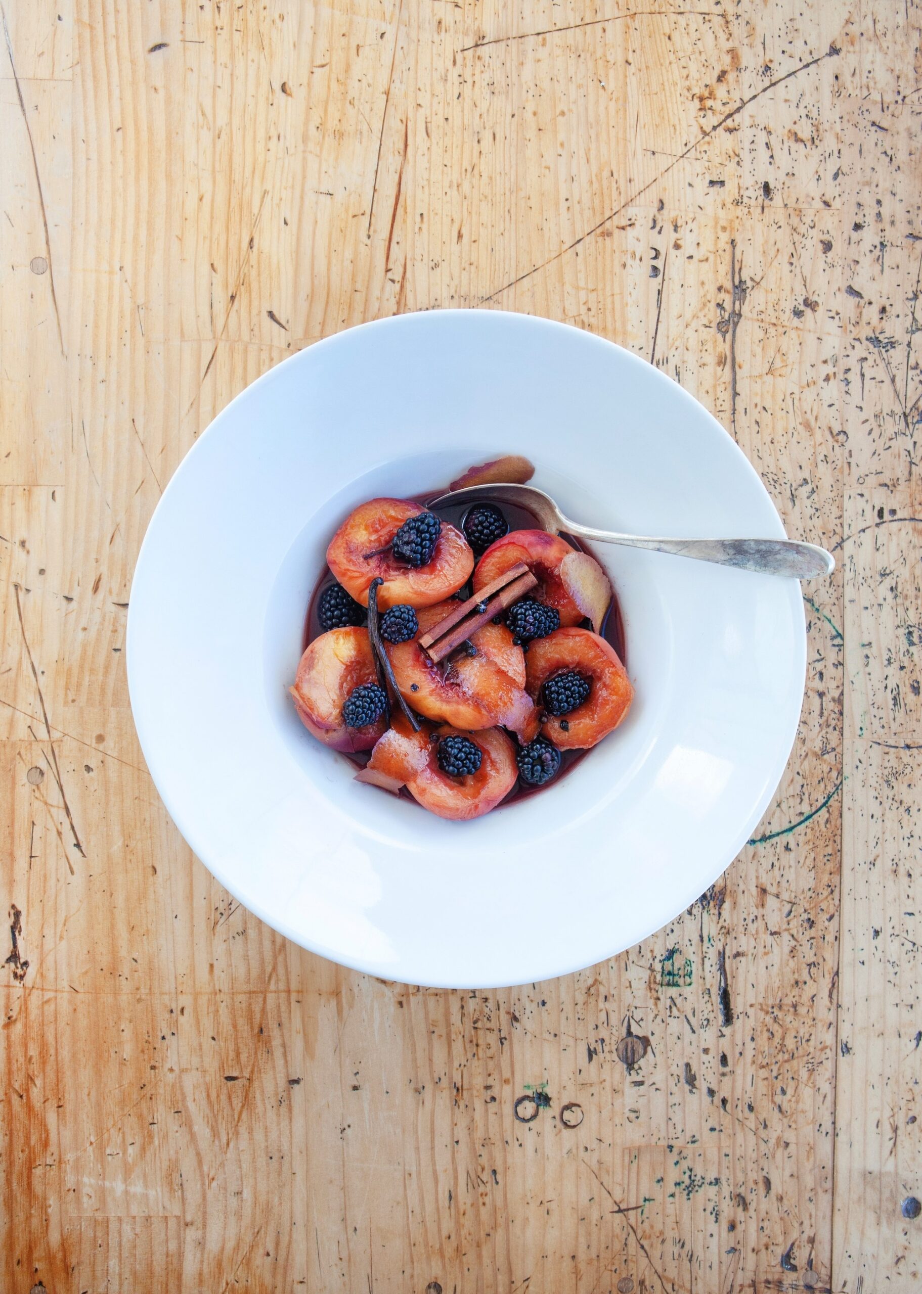 Peaches Poached in Pinot Noir served on white china plate